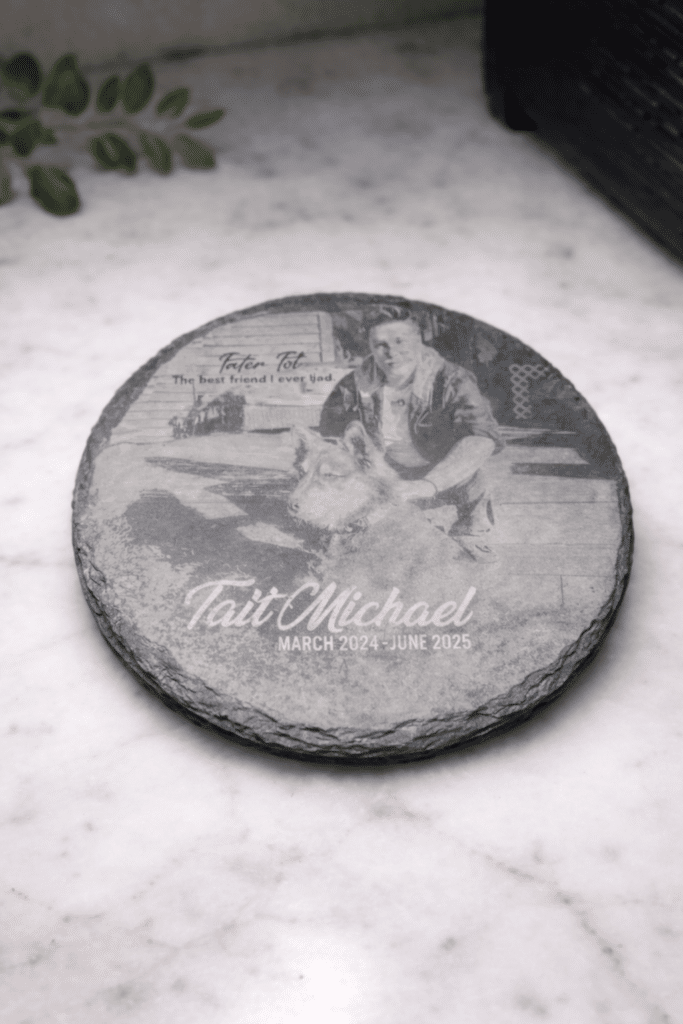 A Custom Laser Engraved Slate Coaster on marble, featuring an image of a man and a dog. Text: Tait Michael, March 2024 - June 2025. The best friend I ever had.