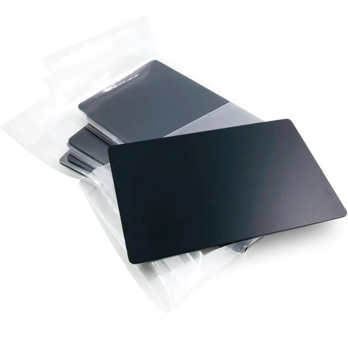 A stack of .8mm Engraved Aluminum Business Cards partially out of a clear plastic bag, with one card prominently displayed in the foreground.