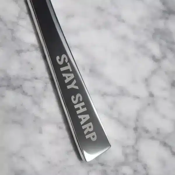 A close-up of the Premium 9.5 Inch Personalized Butter Knife on a marble surface, engraved with the words STAY SHARP.