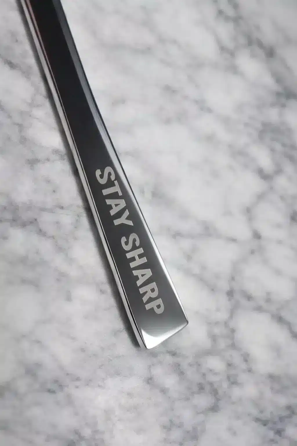 A close-up of the Premium 9.5 Inch Personalized Butter Knife on a marble surface, engraved with the words STAY SHARP.
