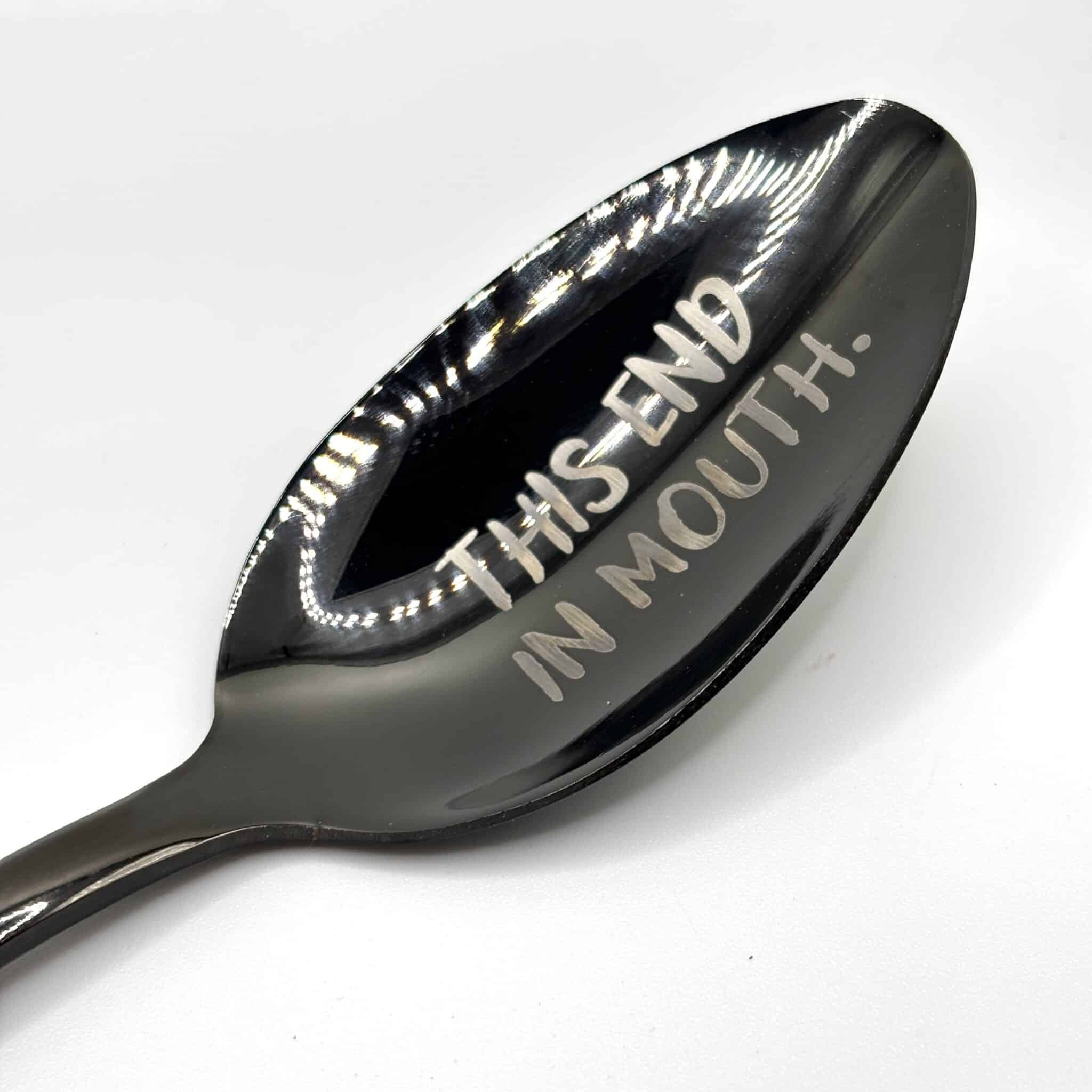 An 8.75" Custom Black Engraved Spoon with "THIS END IN MOUTH." engraved on the bowl, displayed against a white background.
