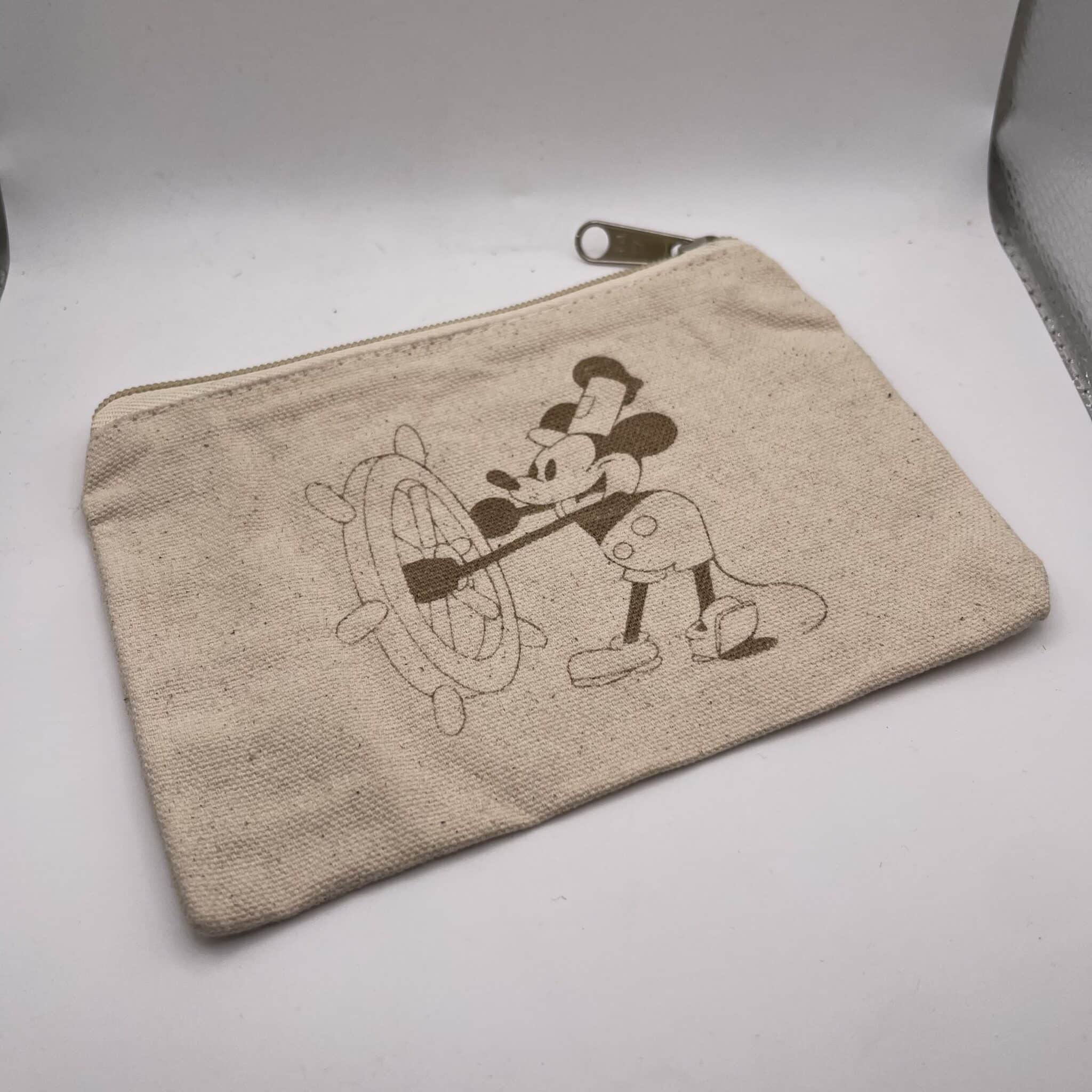 Beige fabric pouch with a zipper and a partial Mickey Mouse print visible on the corner.