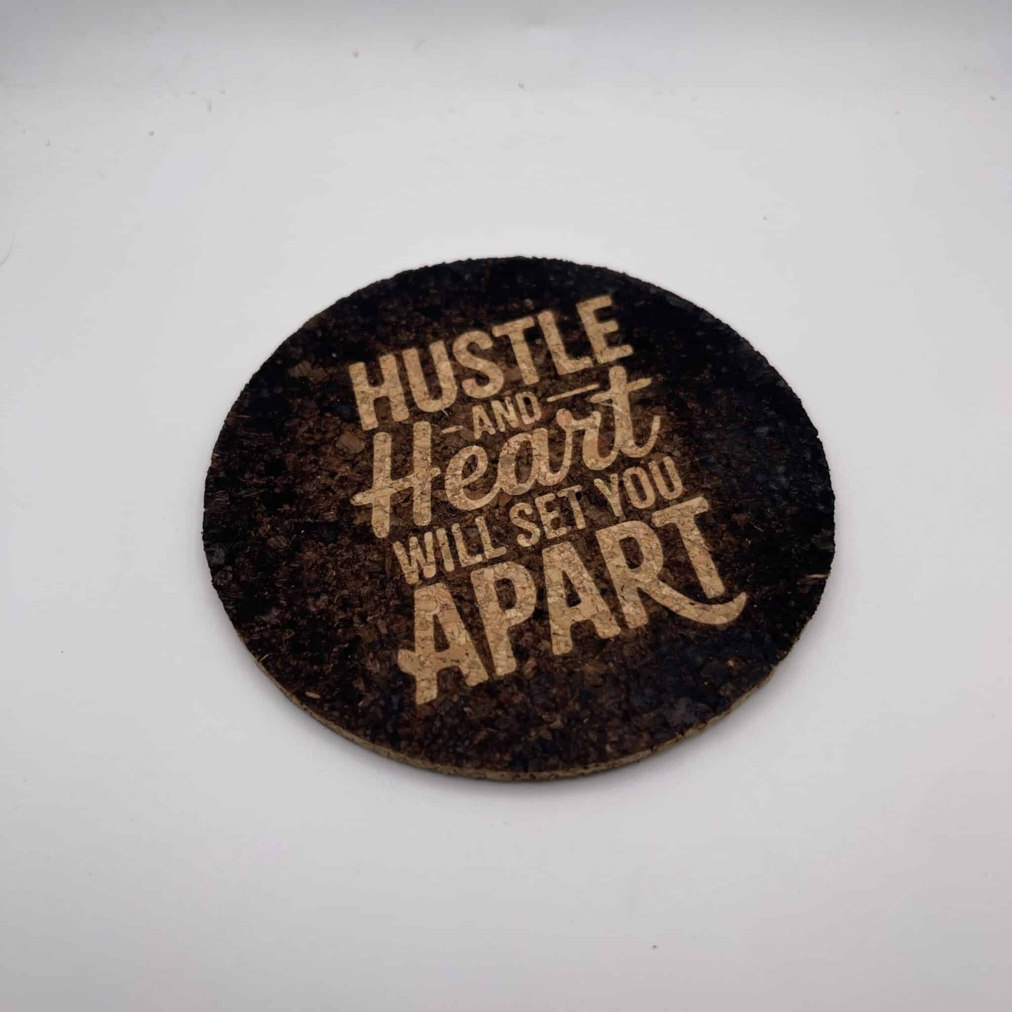 A square, 0.20″ thick photo cork coaster featuring the engraved words “Hustle and Heart Will Set You Apart” in bold, light-colored text, displayed on a plain white background.