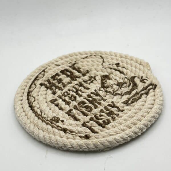 A round, coiled rope mat with brown text and a design on its surface, placed on a plain white background.